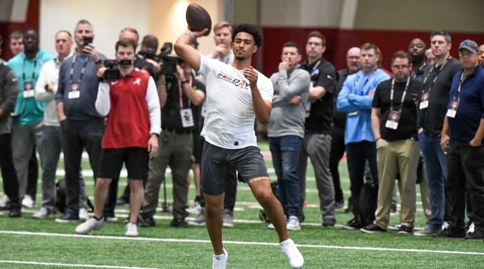 Quarterback Bryce Young throws during Pro Day as coaches stand behind and watch him